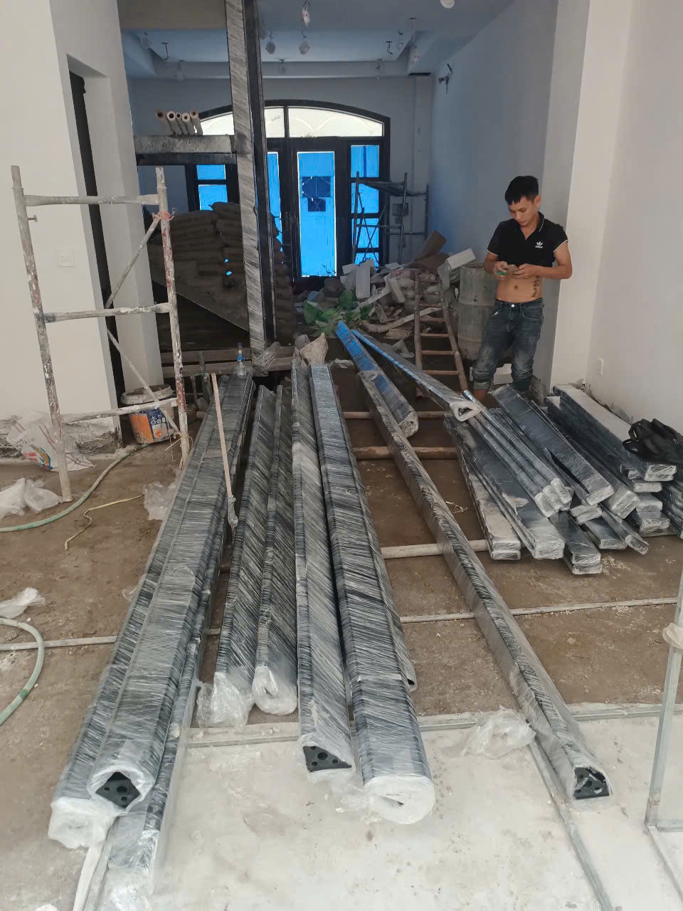 Thanh nhôm định hình bọc nilon xếp trên sàn trong công trình đang thi công nội thất